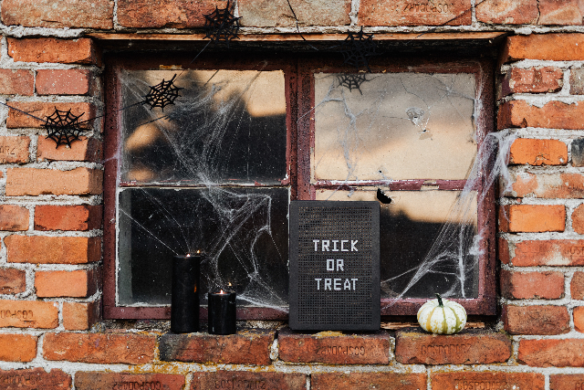 Ein Fenster mit Spinnennetzen und Spinnen zum Halloween