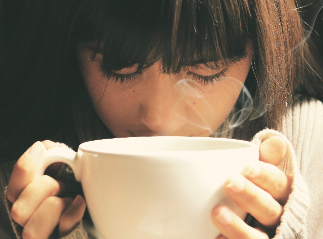 Ein Mädchen trägt ein Kaffee in der Hand